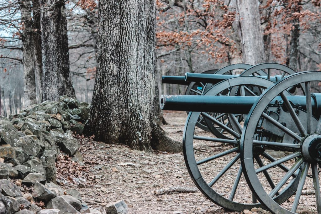 Cannons, trees, and rock wall in Gettsysburg.