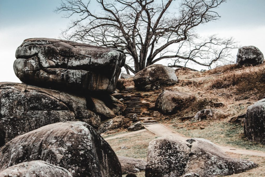 Devil's Den in Gettysburg. Large boulders, rocky staircase and path, tree in distance.